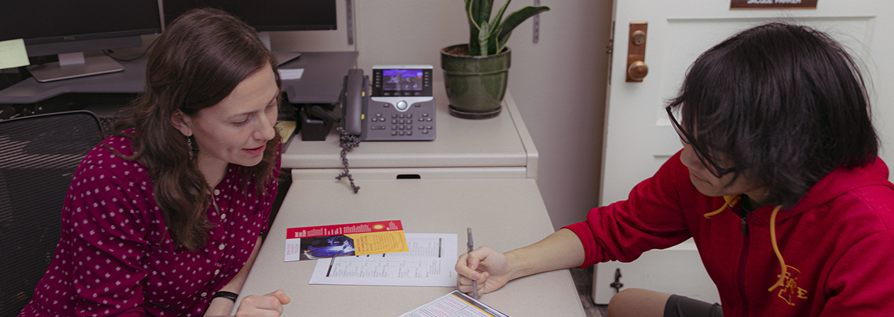 A student and an adviser going over an academic plan in an office